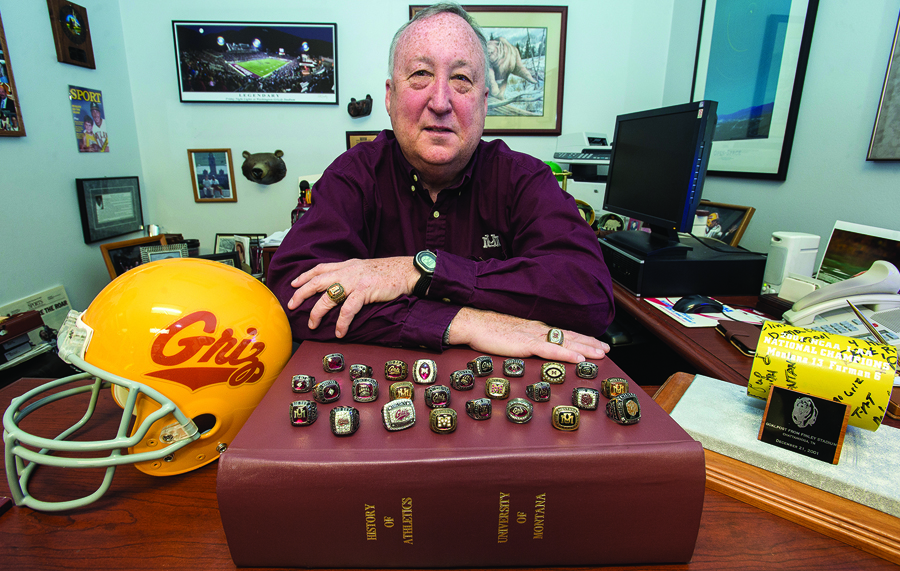Dave Guffey has accrued quite the collection of Griz memorabilia during his career, including twenty-six championship rings perched here atop The Red Book. The two he wears are from national championships. (Photo by Todd Goodrich)